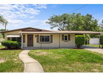 Charming single story home with well-maintained lawn, a walkway, and a covered front porch and carport at 891 N Wayman St, Longwood, FL 32750