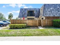 Exterior of townhome featuring a wood fence, balcony and well-maintained landscaping at 917 Royal Oak Blvd, Leesburg, FL 34748