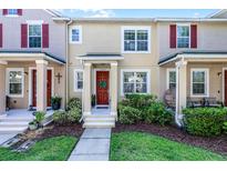 Charming townhouse with a well-maintained lawn and a welcoming red front door with a lovely green wreath at 10255 Hartford Maroon Rd, Orlando, FL 32827