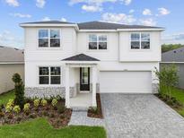 Charming two-story home with stone accents, a well-manicured lawn, and a paved driveway at 13240 Pergola Ave, Orlando, FL 32832