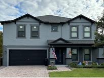Charming two-story home with a black garage door, manicured lawn, and a welcoming front entrance at 2926 Boating Blvd, Kissimmee, FL 34746