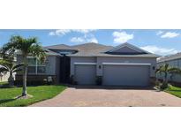 Charming single-story home featuring a well-manicured lawn, two-car garage, and brick driveway at 3986 Bedford Ave, Winter Haven, FL 33884