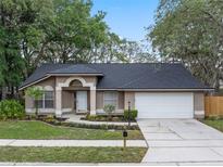 Charming one-story home featuring a two-car garage and a beautifully landscaped front yard with mature trees at 4161 Leafy Glade Pl, Casselberry, FL 32707