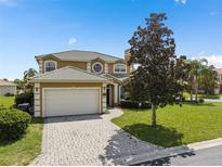 Stunning home with a beautiful paver driveway, lush landscaping and a tile roof at 426 Vista Loop, Davenport, FL 33897