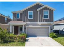 Charming two-story home with a two-car garage, landscaped yard, and neutral colors at 942 Jackson Ave, Davenport, FL 33837