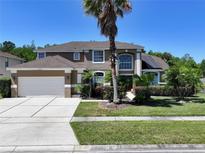 Charming two-story home with a lush landscaped yard, a two-car garage and solar panels on the roof at 12618 Greco Dr, Orlando, FL 32824