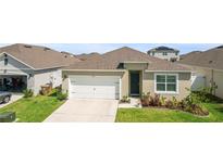 Charming single-Gathering home with well-maintained lawn and an attached two-car garage at 1975 Cacutta Way, Kissimmee, FL 34744