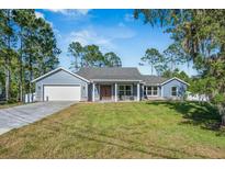 Charming single-story home features a blue exterior, well-manicured lawn, and an attached two-car garage at 2049 Eldorado Ct, St Cloud, FL 34771