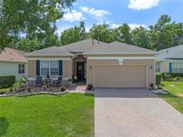 Charming single-story home featuring a two-car garage and a welcoming front yard with beautiful landscaping at 2217 Caledonian St, Clermont, FL 34711