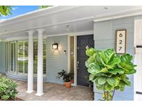 Inviting front door with stone steps and a bay window featuring white framed windows at 627 Darcey Dr, Winter Park, FL 32792