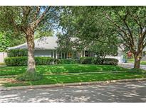 Charming single-story home with mature trees, lush lawn, and manicured shrubbery at 627 Darcey Dr, Winter Park, FL 32792