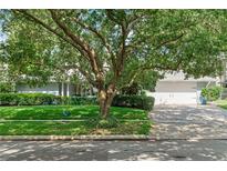 Charming single-story home with mature tree, lush green lawn, and brick-paved driveway at 627 Darcey Dr, Winter Park, FL 32792