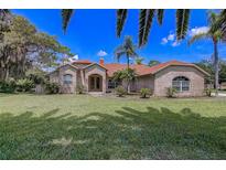 Charming brick home with lush lawn, mature trees, and inviting curb appeal at 12202 Rambling Oak Blvd, Orlando, FL 32832