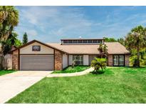 Charming single-story home featuring a brick and vinyl exterior, lush lawn, and an attached garage with a basketball hoop at 140 Margate Mews, Longwood, FL 32779