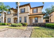Inviting two-story condo featuring a stucco facade, manicured landscaping, and a welcoming entrance at 202 Napoli Dr # 202, Davenport, FL 33897