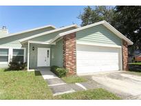 Charming one-story home with a two-car garage and well-maintained lawn at 2828 Whispering Way, Winter Park, FL 32792