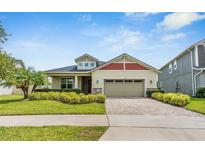 Charming single-Gathering home featuring a manicured lawn, brick driveway, and a two-car garage at 2938 Bushmead Ct, Ocoee, FL 34761