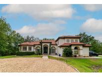 Elegant single-story home with a red tile roof, arched entryway, and circular driveway at 3437 Coronet Ave, Orlando, FL 32833