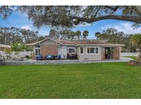 Charming single-story home with a brick facade, inviting patio, and lush green lawn at 434 S Beach St, Ormond Beach, FL 32174