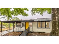 Charming single-story home with a bright yellow front door and covered carport at 6354 Hill Rd, Orlando, FL 32810