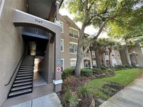 Inviting multi-story condo building with well-maintained landscaping, mature trees, and convenient stairwell access at 7147 Yacht Basin # 132, Orlando, FL 32835