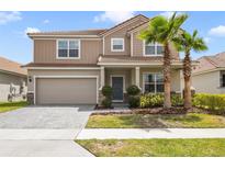Charming two-story home features a two car garage, tile roof, front yard landscaping and brick paved drive at 1115 Oak Bluff Dr, Davenport, FL 33837
