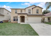 Two-story home featuring a two-car garage, neutral paint, a lawn, and a front door at 1455 Blue Horizon Dr, Clermont, FL 34714