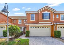 Charming townhouse featuring a two-car garage, tile roof, and well-maintained landscaping at 1942 Michael Tiago Cir, Maitland, FL 32751