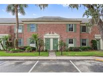 Charming two-story brick townhouse with lush landscaping and a well-maintained front yard and green doors at 316 Georgetown Dr # 316, Casselberry, FL 32707
