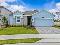Charming one-story home with a blue facade, well-manicured lawn, and stylish stone accents at 8018 Colby Cir, Orlando, FL 32817