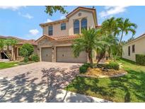 Beautiful two-story home with a paver driveway, two-car garage and lush, tropical landscaping at 8439 Prestbury Dr, Orlando, FL 32832
