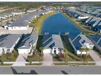 An aerial view of a community showcasing landscaping, a lake, and modern single-Gathering homes at 891 Megano Blvd, Deland, FL 32724