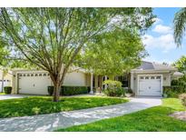 Beautiful home featuring a paved driveway, mature landscaping, and a three car garage at 9104 Stromboli Ct, Kissimmee, FL 34747