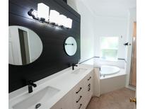 Modern bathroom featuring double sinks, sleek black fixtures, and a soaking tub at 10255 Cody Ln, Orlando, FL 32825