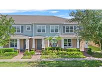 Charming townhome featuring a well-manicured lawn and a welcoming front porch at 15651 Kinnow Mandarin Ln, Winter Garden, FL 34787