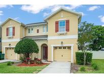 Two-story tan home featuring a front yard with a tree and a single-car garage at 1774 Peterson Pl, Sanford, FL 32773