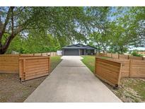 Charming home featuring a long driveway and gated wooden fence offering privacy and curb appeal at 2415 S Oak Ave, Sanford, FL 32771