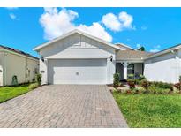 Charming home featuring a two-car garage, well-manicured lawn, and a beautifully paved driveway on a sunny day at 2458 Cliff Way, St Cloud, FL 34771