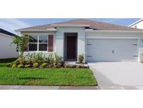 Charming single-story home featuring a well-manicured lawn, a two-car garage, and inviting curb appeal at 2597 Trinidad Rd, Haines City, FL 33844