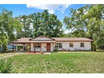 Charming single-story home with a well-manicured lawn and mature trees offering shade and curb appeal at 474 Overstreet Ave, Longwood, FL 32750