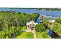 Stunning aerial view of waterfront home with lush trees and expansive waterway views at 6375 Topsy Trl, St Cloud, FL 34771