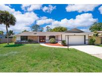 Charming single-story home with a well-manicured lawn, brick accents, red front door, and attached garage at 713 Coach Light Dr, Fern Park, FL 32730
