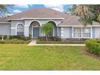 Charming single-story home features a well-manicured lawn, lush landscaping, and a welcoming entrance at 7978 Sea Pearl Cir, Kissimmee, FL 34747