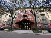 Exterior shot of a well-maintained apartment building with a covered entrance and a professionally landscaped walkway at 911 N Orange Ave # 545, Orlando, FL 32801