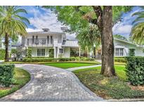 Stunning two-story home with a beautifully landscaped yard and a curved brick driveway at 940 Lincoln Cir, Winter Park, FL 32789
