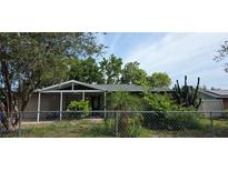 Cozy single-story home featuring a screened front porch and lush landscaping, creating a private and inviting entrance at 1302 Center St, Ocoee, FL 34761