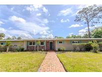 Charming single-story home featuring a brick facade, well-manicured lawn, and inviting walkway at 2001 Lily Ct, Sanford, FL 32771