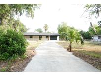 Charming single-story home with a long driveway and lush landscaping at 240 W Palmetto Ave, Deland, FL 32720