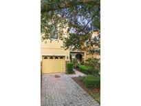 Charming yellow two-story home with a brick driveway and well-maintained landscaping in a suburban neighborhood at 2829 Shady Willow Ln, Oviedo, FL 32765