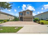 Charming two-story home with brick driveway, attached garage, and well-maintained landscaping at 341 Falls Dr, Kissimmee, FL 34747